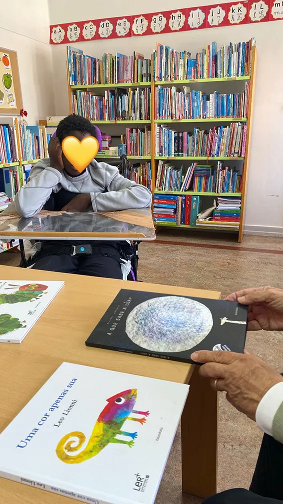 uma crianca uma mesa com livros infantis