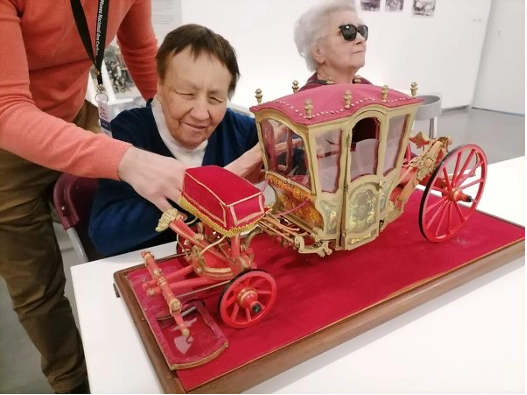 utente com uma miniatura de coche no museu dos coches