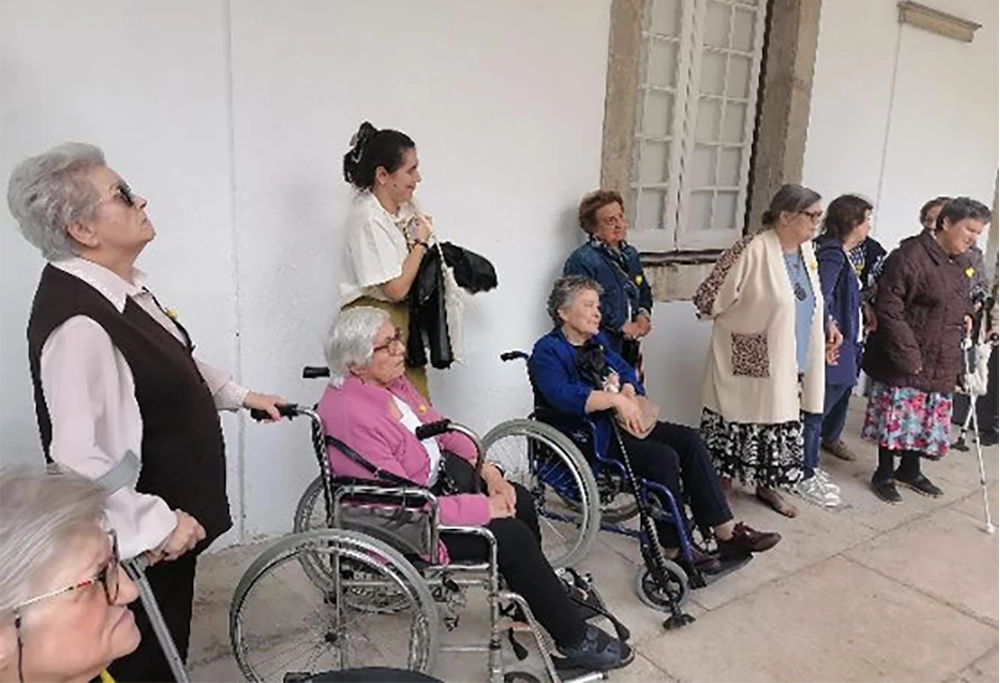 idosos e utentes junto a uma casa
