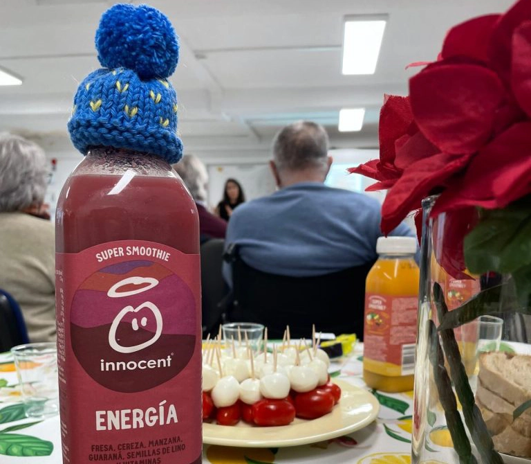 foto de garrafa de bebida de fruta com gorro de lã e costas de utente atras