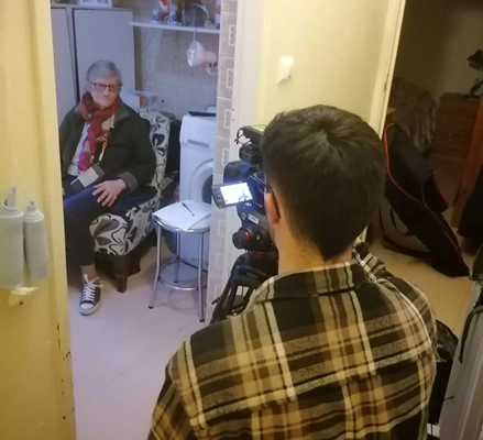 entrevista de um rapaz com camera e uma idosa